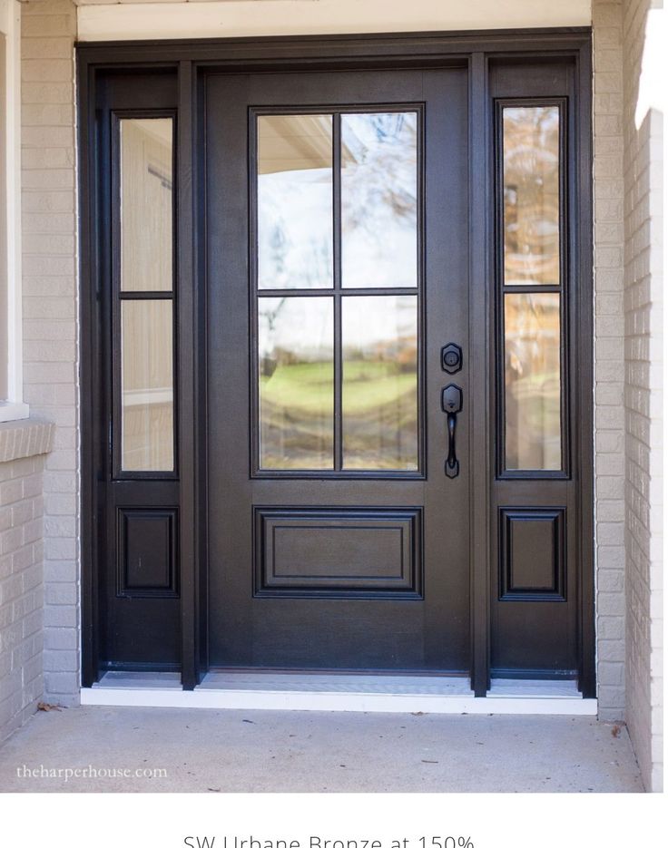 a black front door with two sidelights and glass panels on the top half of it