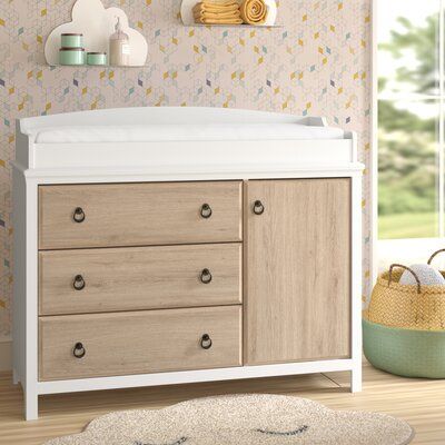 a baby's room with a crib, dresser and rug in the foreground