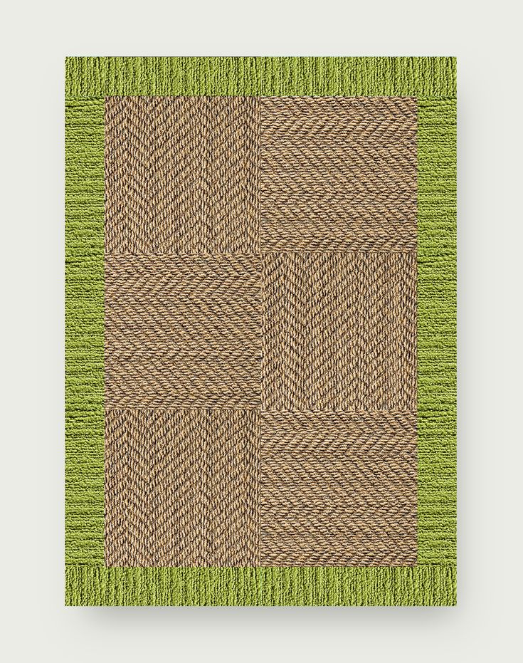 a green and brown area rug on top of a white wall