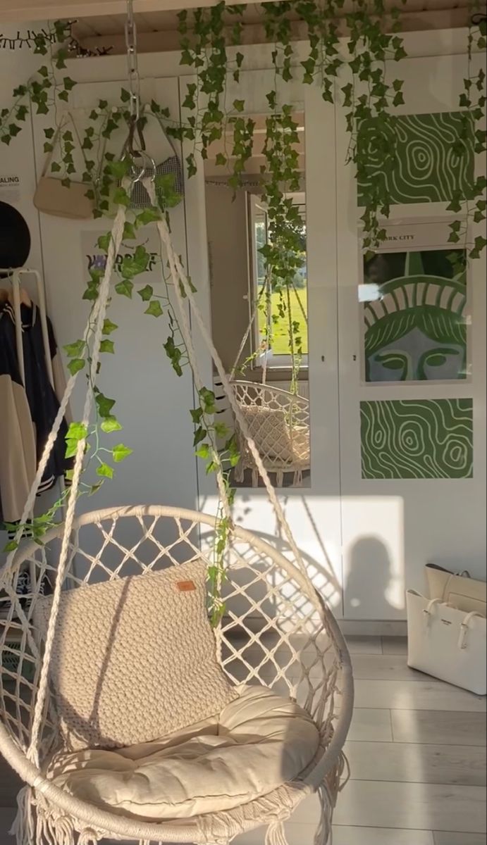 a white hanging chair with green plants on it