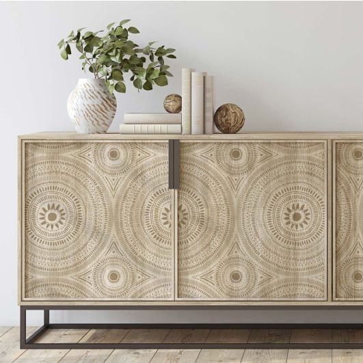 a white vase sitting on top of a wooden sideboard next to a book shelf