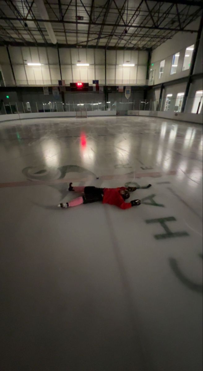 a person laying on the ice in an empty building