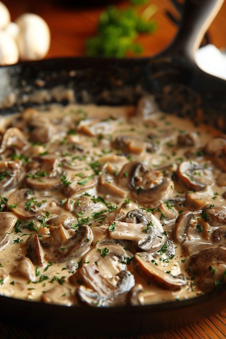 a skillet filled with mushrooms on top of a wooden table