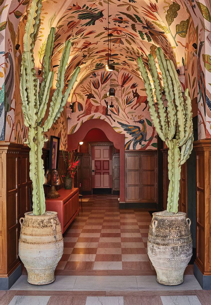 a hallway with several large vases and paintings on the walls