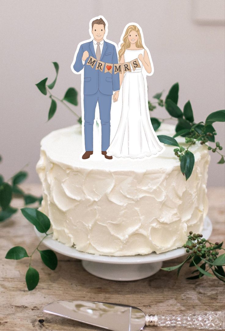 a wedding cake topper with a bride and groom cut out on it, surrounded by greenery