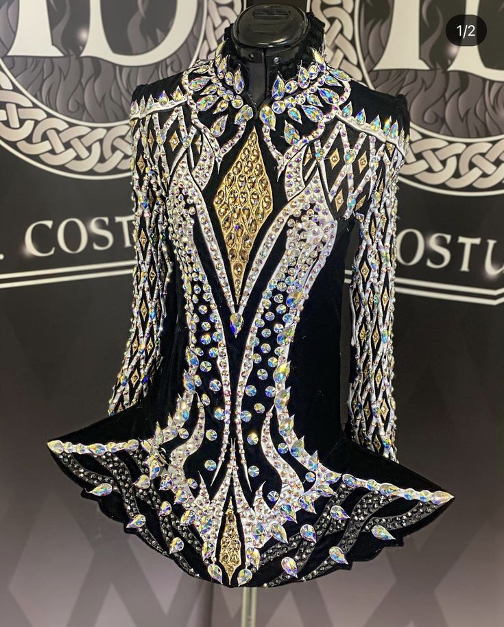 a black and gold dress on display in front of a sign that says, the costume is