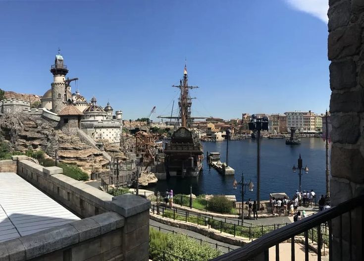 an old pirate ship is docked in the water next to a stone wall and walkway