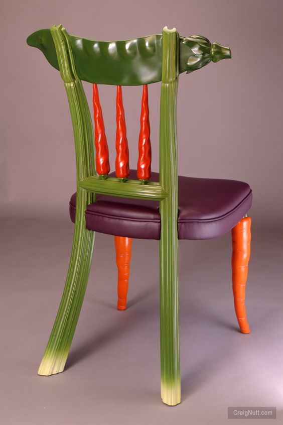 a green chair with carrots painted on it's back legs and seat, against a gray background