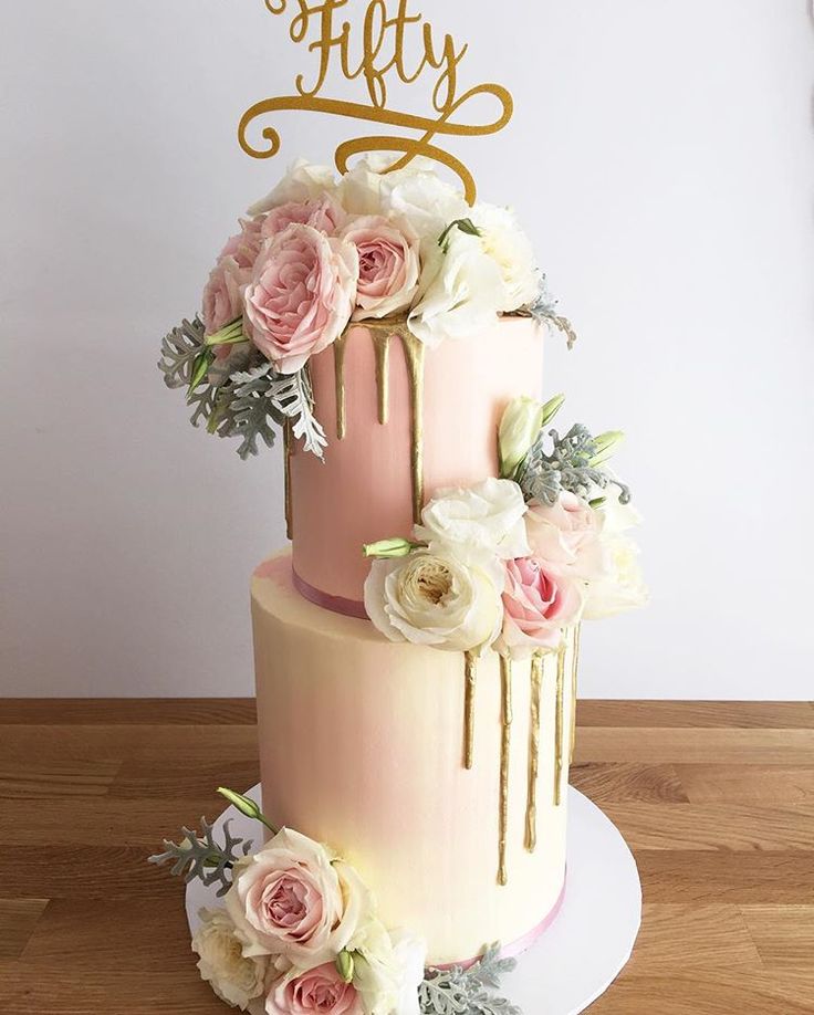 a pink and gold wedding cake with flowers on the bottom tier is featured in this video