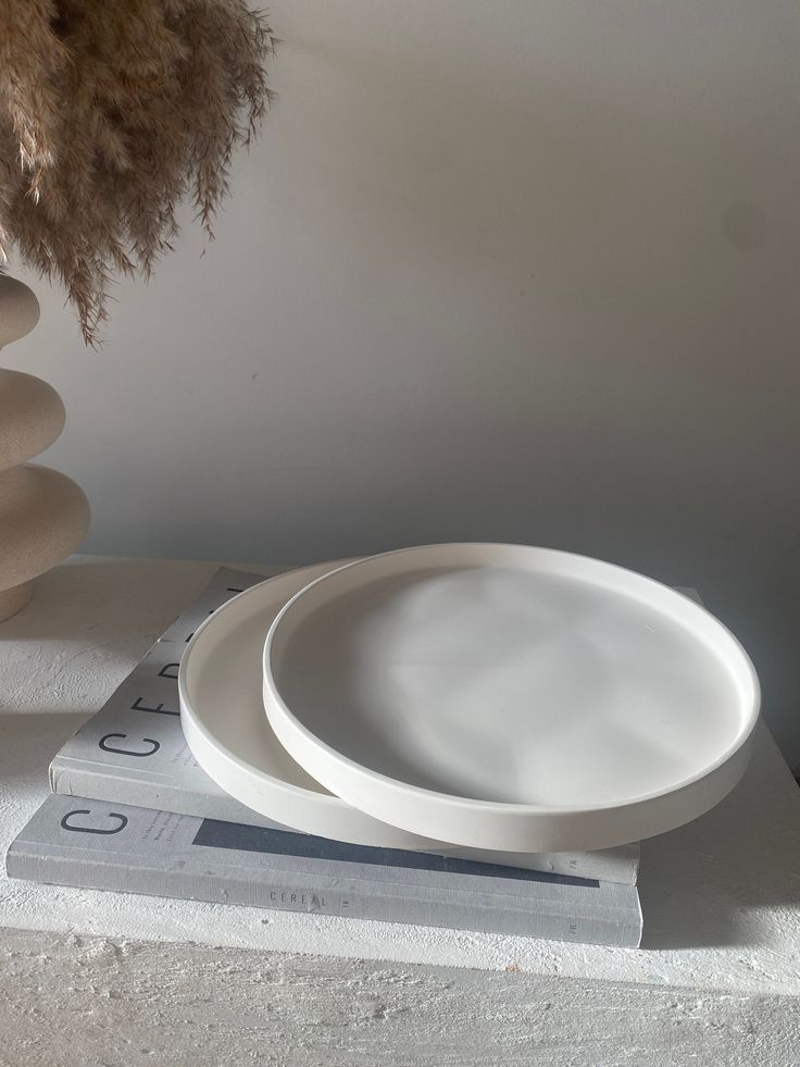 a white plate sitting on top of a stack of magazines