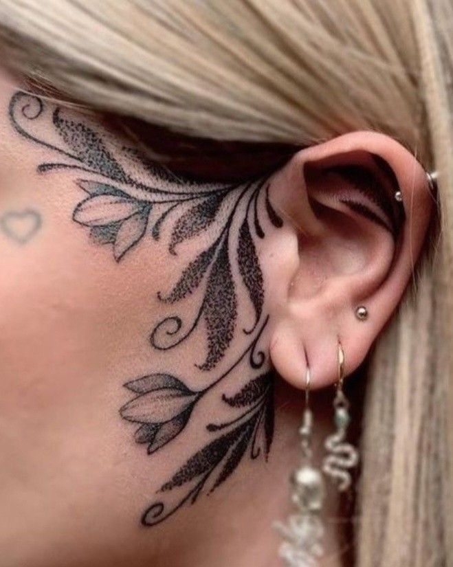 a woman with tattoos on her neck and behind the ear is an ear piercings