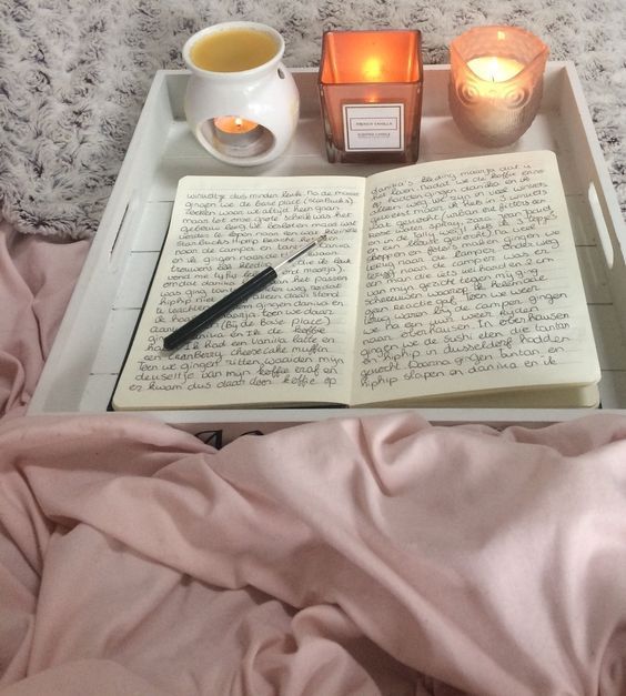 an open book and candle on a tray