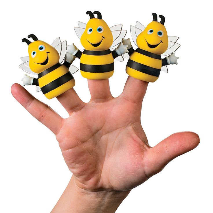 three little bees sitting on top of each other in front of a person's hand