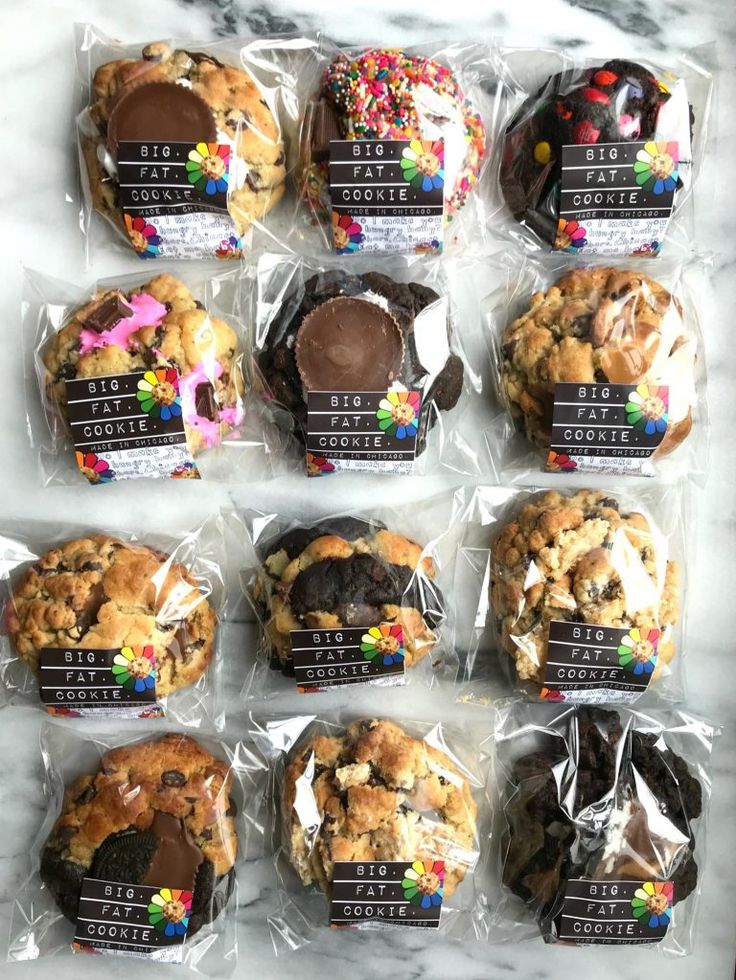 chocolate chip cookies are wrapped in plastic on a marble countertop, with candy and sprinkles