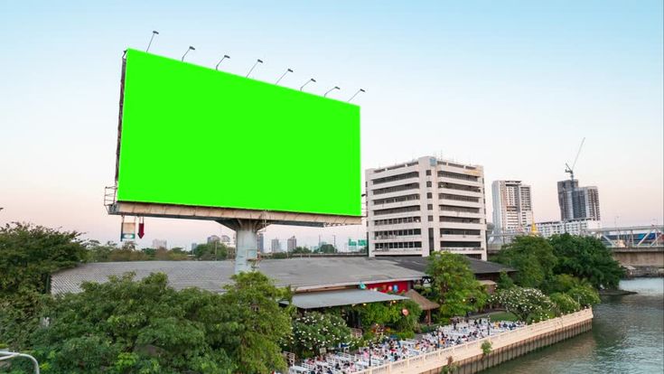 a large green billboard on the side of a river