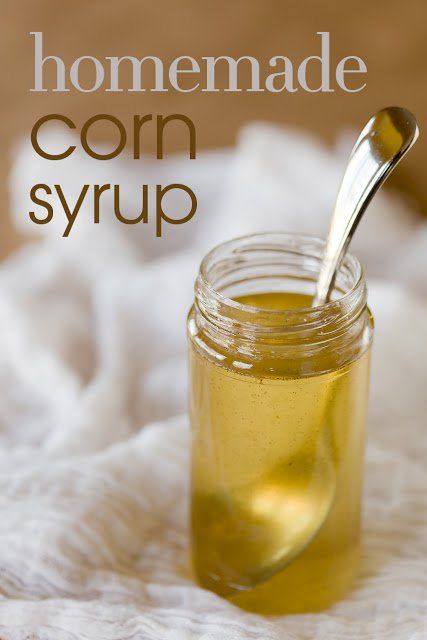 a jar filled with corn syrup on top of a white towel next to a spoon