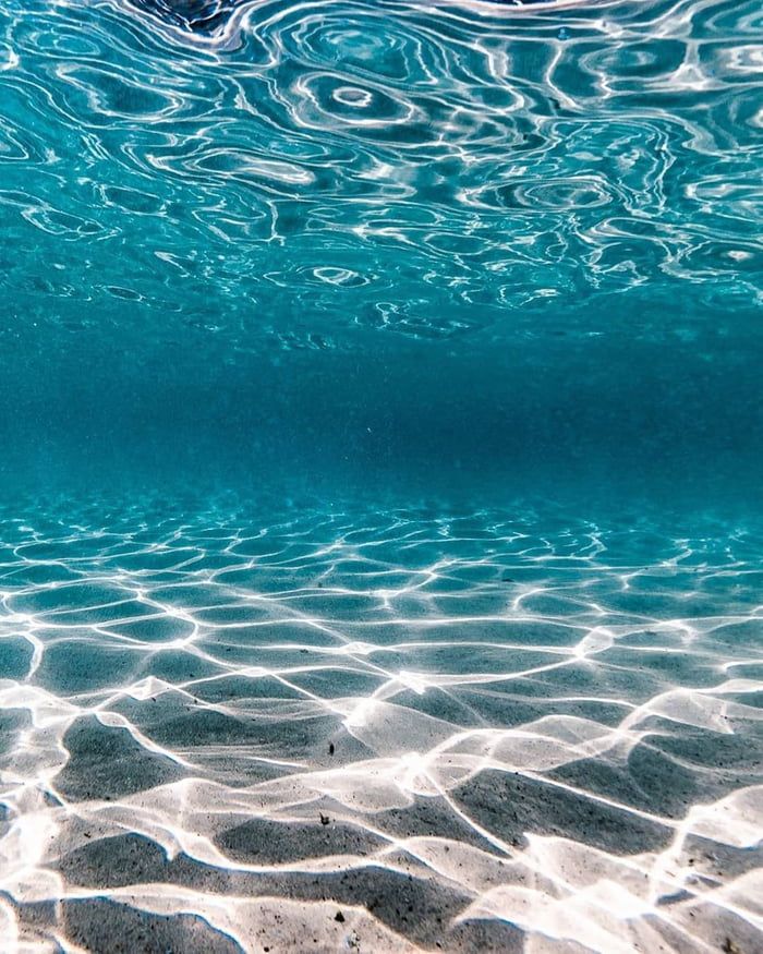 the water is very clear and blue with some waves coming in on it's surface