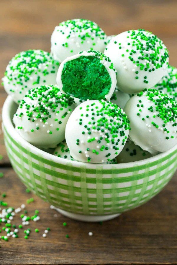 green and white cupcakes with sprinkles in a bowl on a wooden table