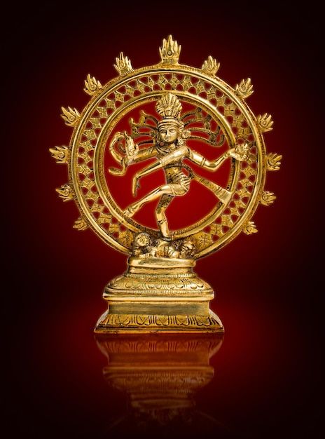 a golden statue with an intricate design on it's face and arms, in front of a red background