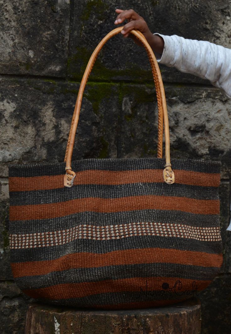 Baobab market Bag | Kiondo Bag | Baobab Basket | Shopping Bag | Farmers Market Bag | Weekend Bag This beautiful handwoven basket is made from baobab fibers. Beautifully weaved by the amazing and the talented women of the Kamba Community in Kenya. This bag is a labor of love. The baobab fibers are skillfully stripped and hand twisted and later naturally dyed to create the beautiful natural colors in black and earth brown. Leather handles are added by the skillful Leather man. The top is left  ope Handwoven Bucket Tote Bag For Daily Use, Woven Bucket Bag Tote, Artisan Handwoven Shoulder Bag For Everyday, Fair Trade Basket Crochet Bag For Travel, Natural Woven Shoulder Bag, Natural Weaving Shoulder Bag For Everyday, Fair Trade Crochet Basket Bag For Travel, Natural Shoulder Bag With Weaving, Natural Weaved Shoulder Bag