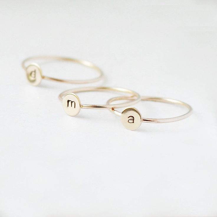 One gold letter ring. Personalize a gift she'll treasure with our gold initial ring. An adorably petite initial, imprinted on a 14k gold filled disk - paired with a super skinny (1mm) gold filled band - creates the perfect stacking ring, customized with your monogram. Lovely as a stand alone. Also sits beautifully with multiple initials stacked or our hammered gold stacking ring bands. This gold initial ring arrives custom made to order in your size hand stamped with the letter of your choice. A Simple Personalized Initial Ring For Everyday, Personalized Yellow Gold Initial Ring For Everyday, Everyday Stackable Yellow Gold Rings With Initials, Everyday Personalized Yellow Gold Initial Ring, Gold Sterling Silver Initial Stackable Ring, Gold Sterling Silver Stackable Initial Ring, Everyday Gold Hand Stamped Stackable Rings, Gold Stackable Rings With Initials For Everyday, Everyday Gold Stackable Rings With Initials