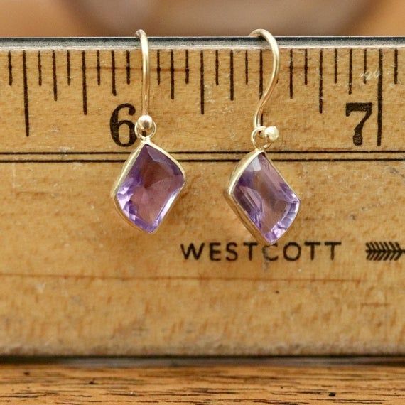 Off center and flowing - these splendid purple orbs shine like you. Rectangular faceted amethyst, dangling off of a hoop back setting. 24k gold vermeil, 3/4" tall. Elegant Gold Amethyst Hoop Earrings, Amethyst Drop Jewelry In Yellow Gold, Fine Jewelry Amethyst Earrings For Pierced Ears, Yellow Gold Amethyst Teardrop Earrings, Gold Amethyst Long Drop Earrings, Purple Long Drop Earrings As Gift, Amethyst Long Drop Earrings For Pierced Ears, Elegant Purple Amethyst Hoop Earrings, Purple Amethyst Long Drop Jewelry