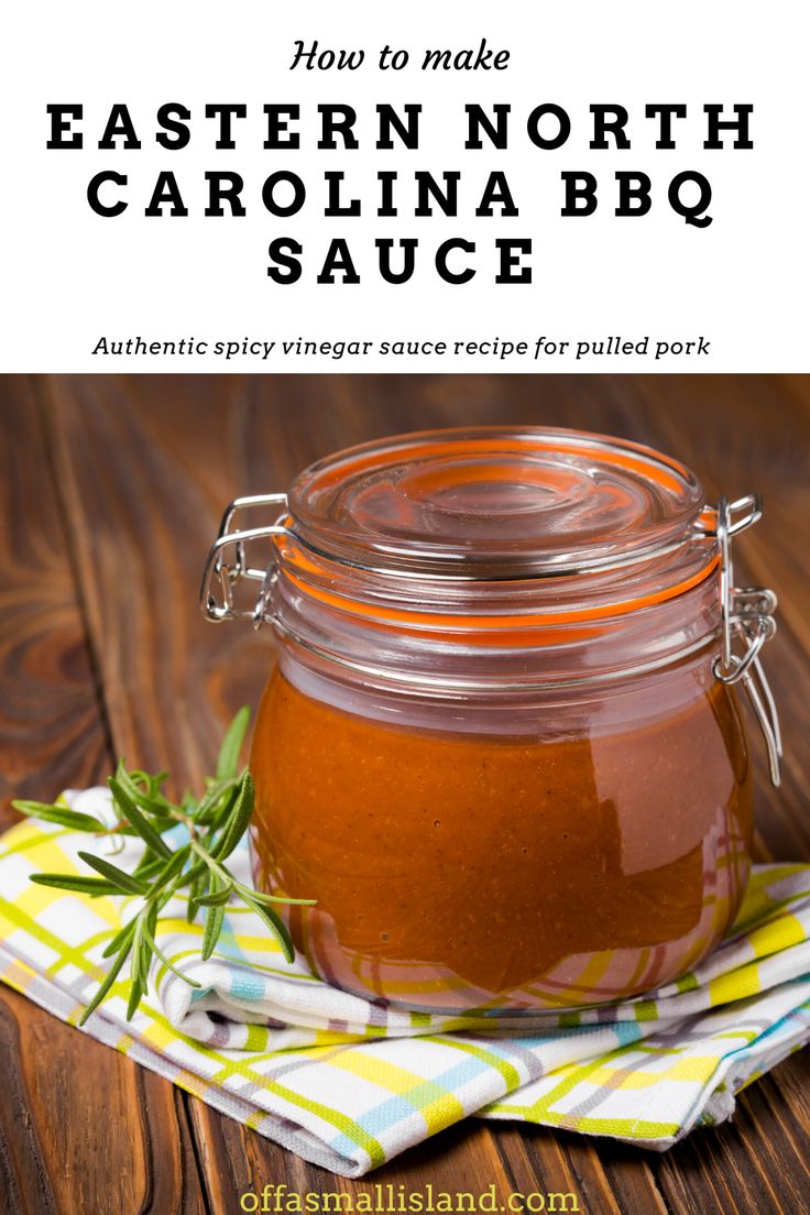 a jar filled with bbq sauce sitting on top of a wooden table next to a napkin