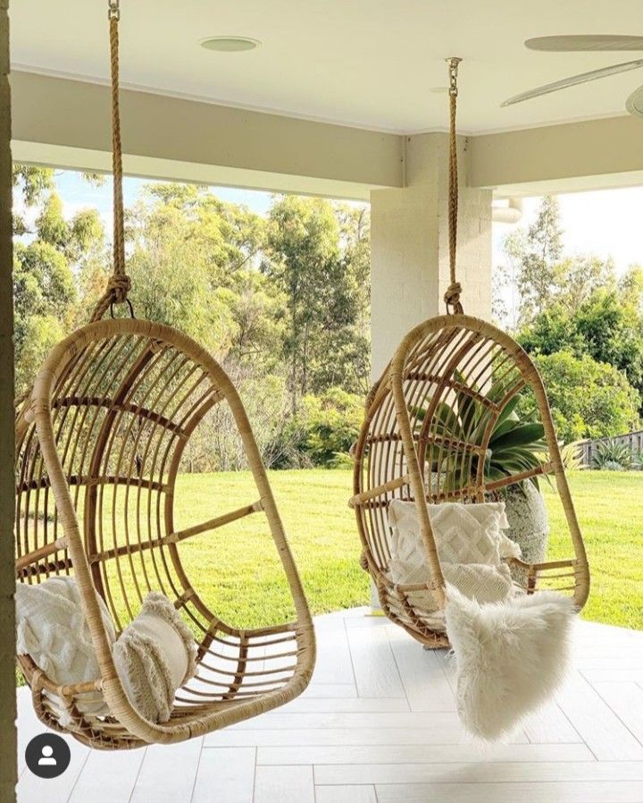 two hammock chairs hanging from the ceiling in front of an open patio area