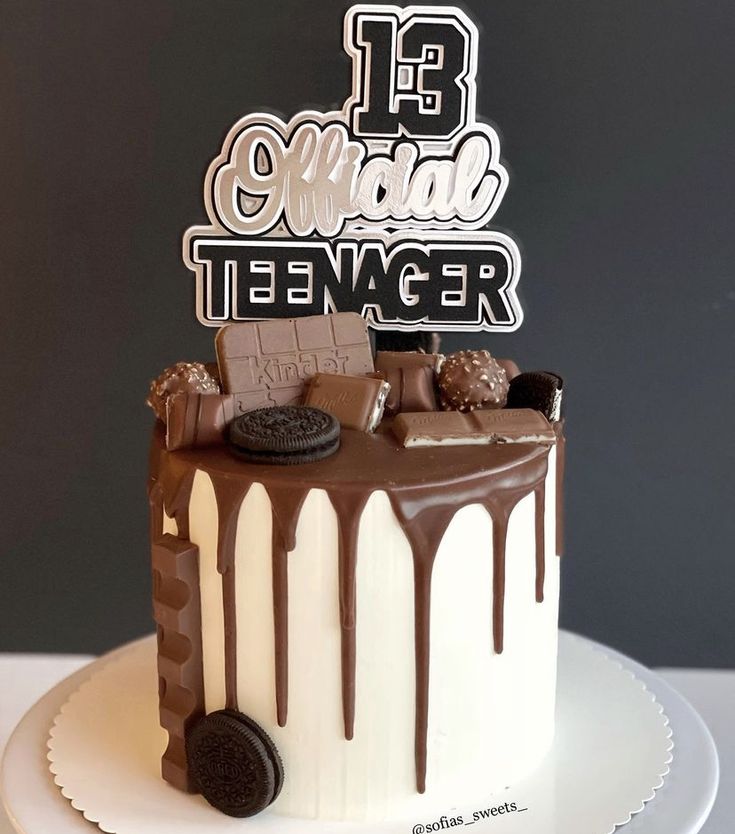 a white cake with chocolate and oreo cookies on top that says 13 congratulations teenager