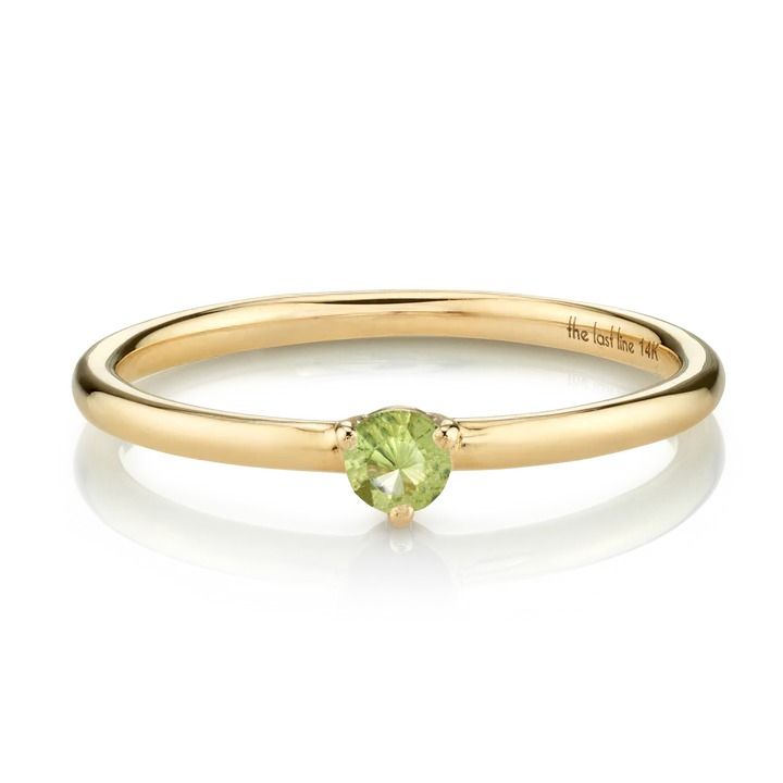 a yellow gold ring with a green stone