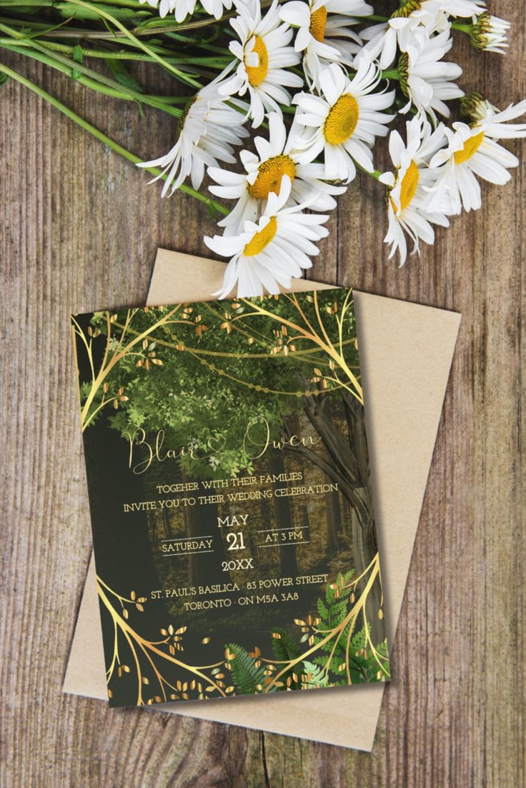 the wedding card has daisies on it and is sitting next to some white flowers