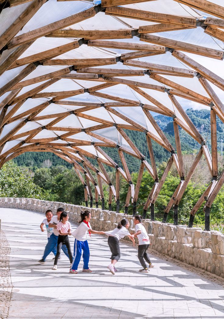 several people are dancing under a wooden structure