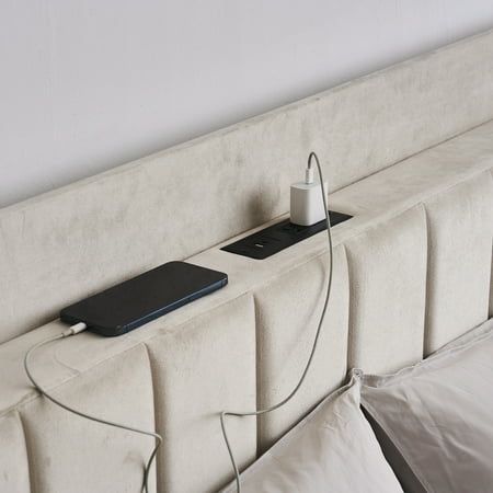 a white headboard with an electronic device plugged into it