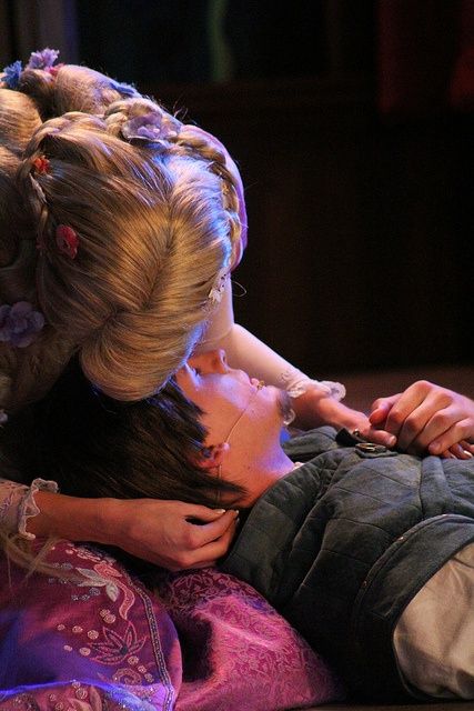 two women sitting next to each other with their hands on the back of one woman's head