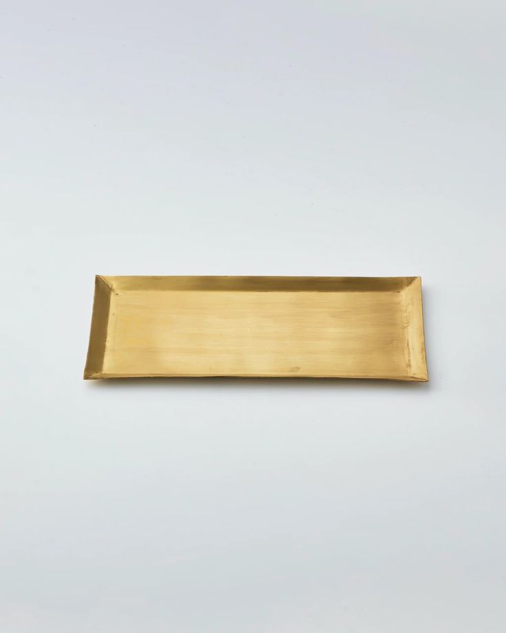 a brass rectangular tray on a white background