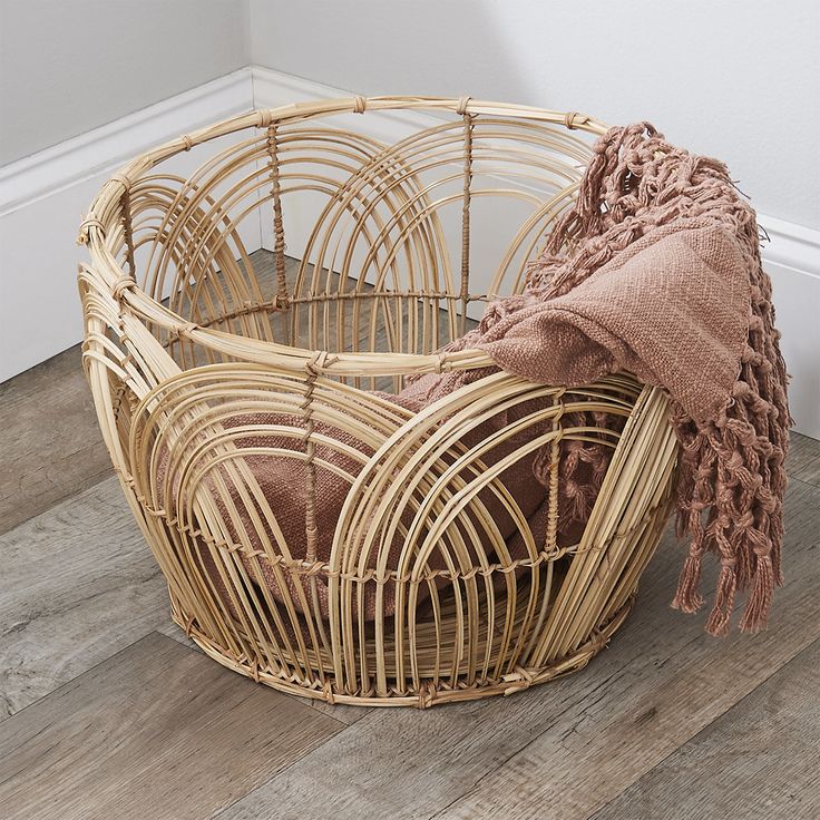 a basket with a blanket sitting on the floor