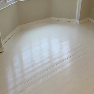 an empty room with white floors and windows