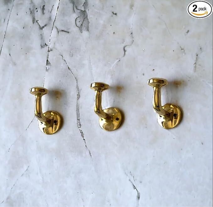 three brass handles on a marble counter top