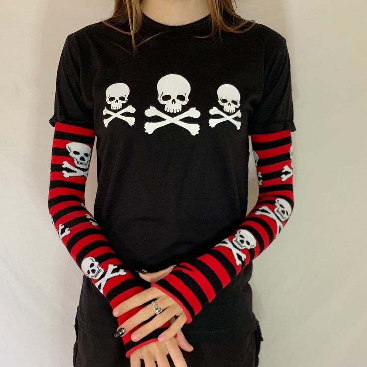 This punky gothic top has rhinestone embellishments on the skulls 100% cotton t-shirt with an Acidcore label.  Red & black skeleton stripe sleeves sewn into the top with thumb holes & fingerless gives this top grunge goth vibes. The sleeves are also available white & black with skulls About Me:  Acidcore is my store based in London. All my items are hand printed with hand made transfers and some are hand embellished. My designs are inspired by different genres, gothic, fairycore, cottagecore, punk, indie. Fitted Gothic T-shirt For Fall, Gothic Skull Print T-shirt For Fall, Alternative Halloween Streetwear Top, Gothic Tops For Winter Alternative Fashion, Punk Style Black Top For Halloween, Emo Long Sleeve T-shirt For Alternative Fashion, Emo Style Long Sleeve T-shirt, Emo Long Sleeve Tops For Concerts, Alternative Skull Print Tops For Streetwear