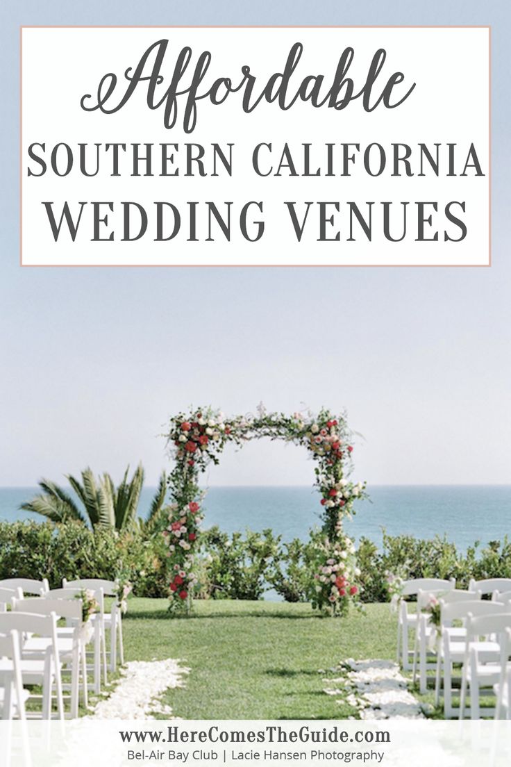 an outdoor wedding venue with white chairs and flowers on the aisle, overlooking the ocean