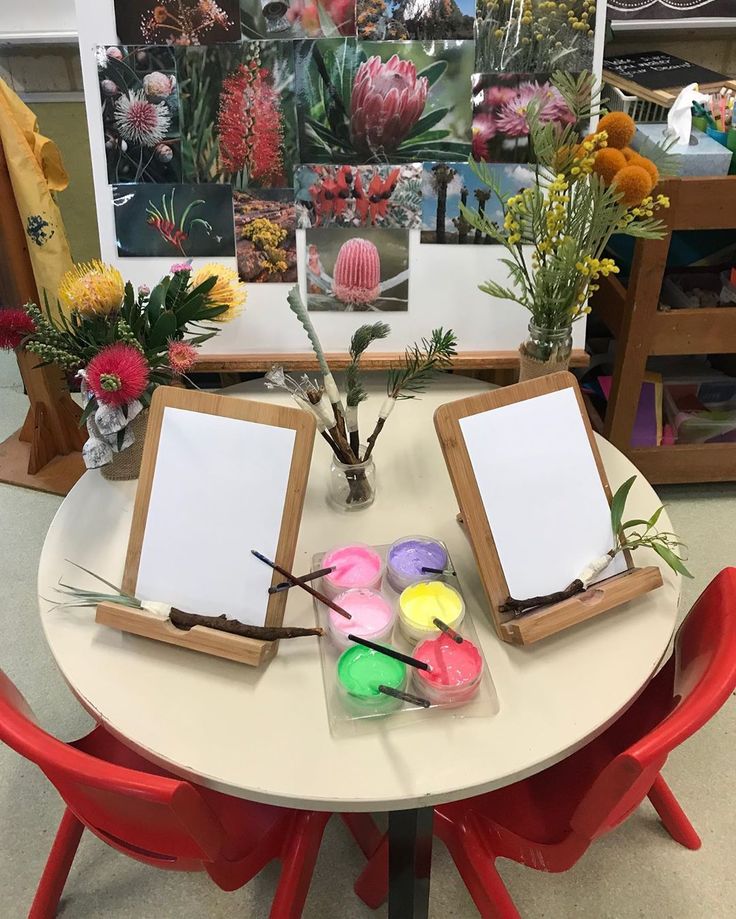 the table is set up with art supplies and flowers