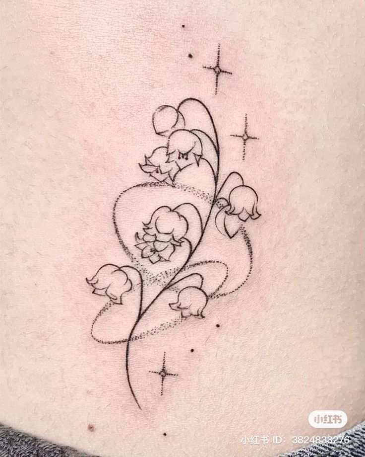 a woman's lower back tattoo with flowers and stars on her left side ribcage