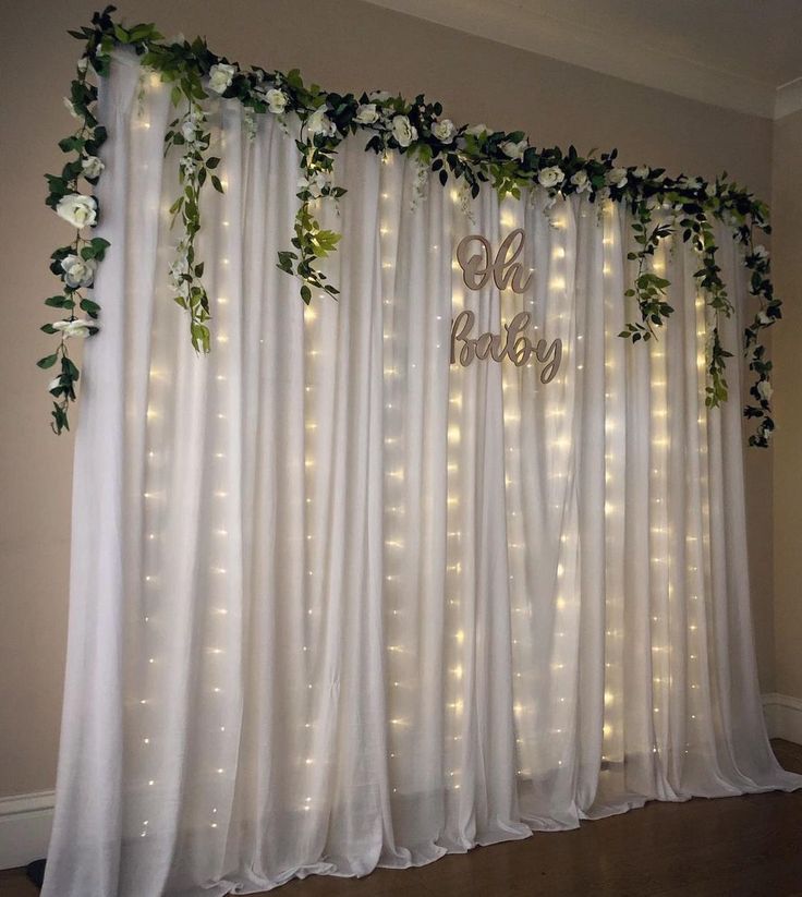 the curtain is decorated with greenery and lights