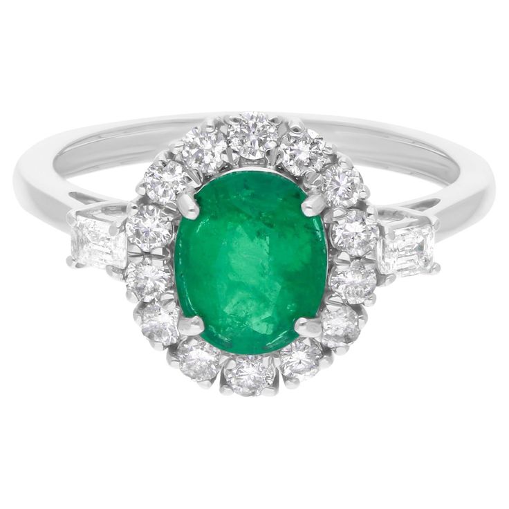 an oval emerald and diamond cluster ring in 18ct white gold, set with diamonds