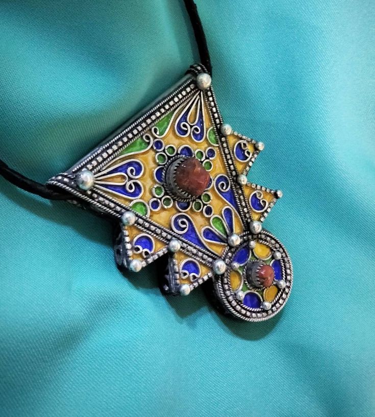 Ancient Berber talisman (herz) in sterling silver, enamelled in blue, green and yellow color. and decorated with a real coral cabochon. Height: 7 cm. Width: 5.5 cm. Leather: 54 cm. ++Material: sterling silver 925, real coral cabochon. ++Weight: 31.8 grams. ++ Origin: Morocco 1970s. Free worldwide shipping by DHL. I am always open to offers for one of my items, so please contact me if you would like to make an offer. Don't hesitate to contact me for any questions. All items advertised for sale ar Amazigh Jewelry, Silver Jews, Solid Necklace, Berber Jewelry, Moroccan Jewelry, Hand Of Fatima, African Jewelry, Amethyst Beads, Green And Yellow