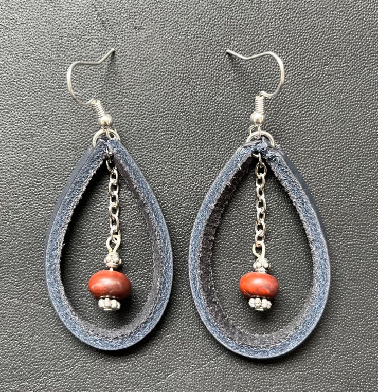 pair of earrings with orange beads and chain hanging from the end of each earring