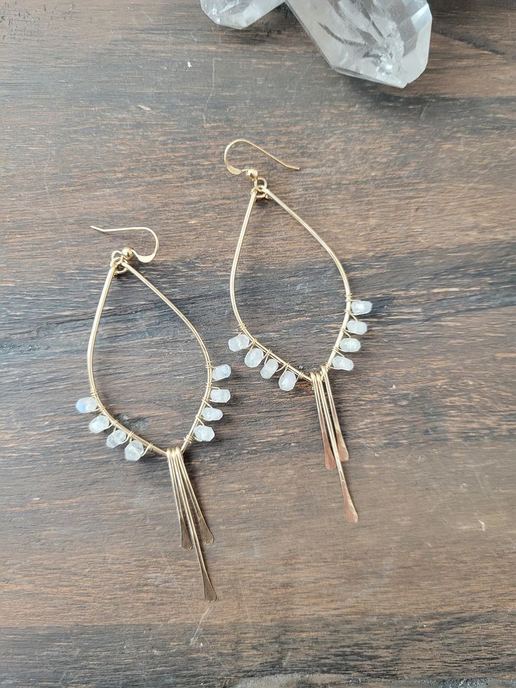 So in love with these Moonstone Tulip Earrings! These beauties are abstract art pieces of tulips that you can wear and take with you on your adventures! They are the perfect addition to your Spring/Summer jewelry and they go with just about anything! They are available in Sterling Silver and 14K Gold Filled. Each piece is hand formed and hammered for texture and shape. Four beautiful Moonstone Gems are wire wrapped up each side of the earring. The length of the earrings are just a tad over 3 in. Artisan Dangle Earrings With Pearl Drop, Artisan Dangle Pearl Drop Earrings, Artisan Teardrop Chandelier Earrings As Gift, Unique Pearl Drop Teardrop Earrings, Unique Teardrop Pearl Drop Earrings, Handmade Delicate Metal Earrings, Bohemian Teardrop Wrap Earrings As Gift, Bohemian Teardrop Wrap Earrings For Gift, Bohemian Dangle Pearl Earrings With Ear Wire