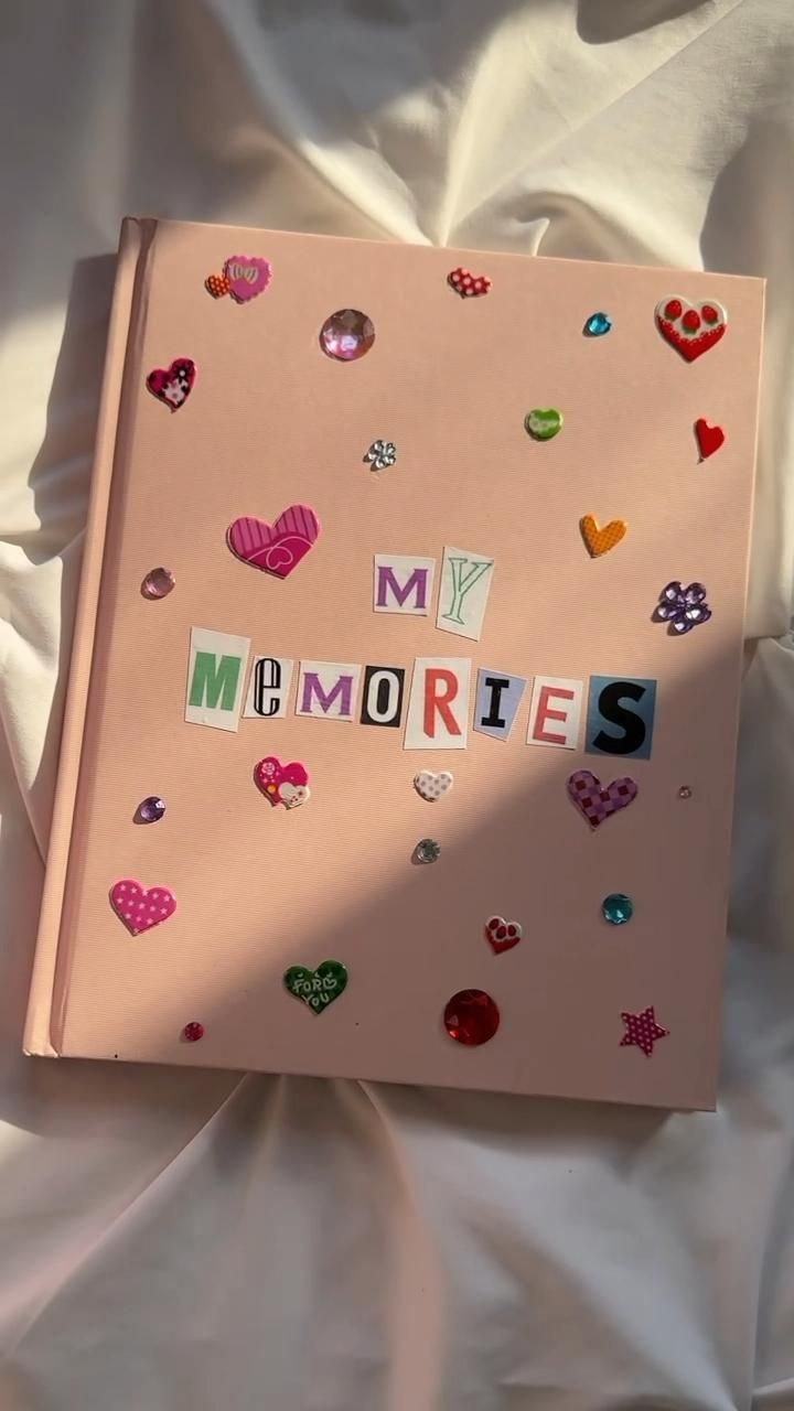 a pink book with the word memories written in cut out letters on top of it