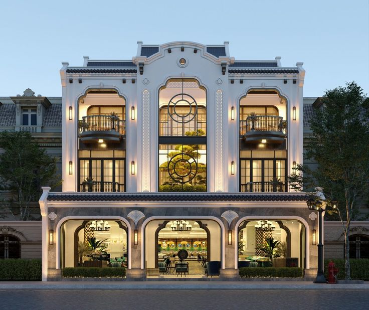 a large white building with lots of windows and lights on it's front entrance