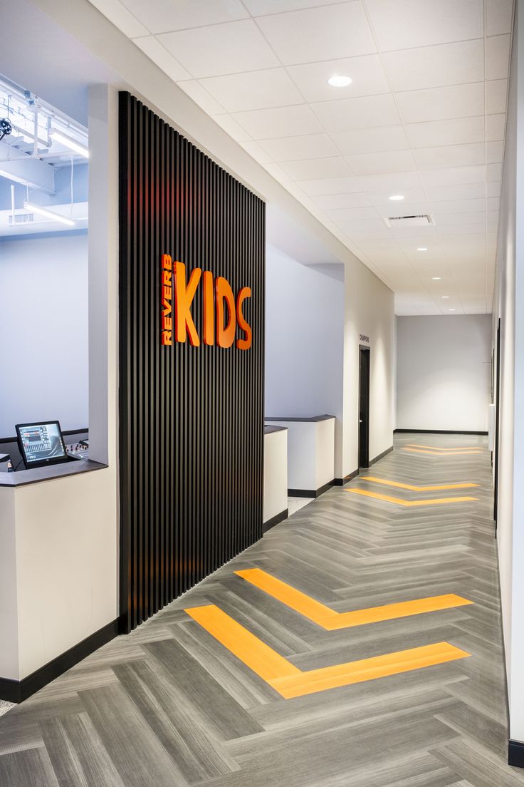 an office hallway with yellow and gray chevron flooring